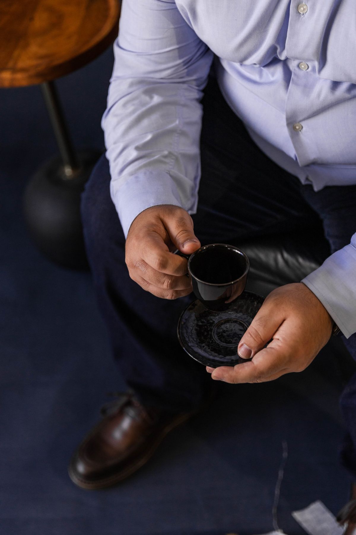 Mãos segurando uma xícara de café durante uma conversa